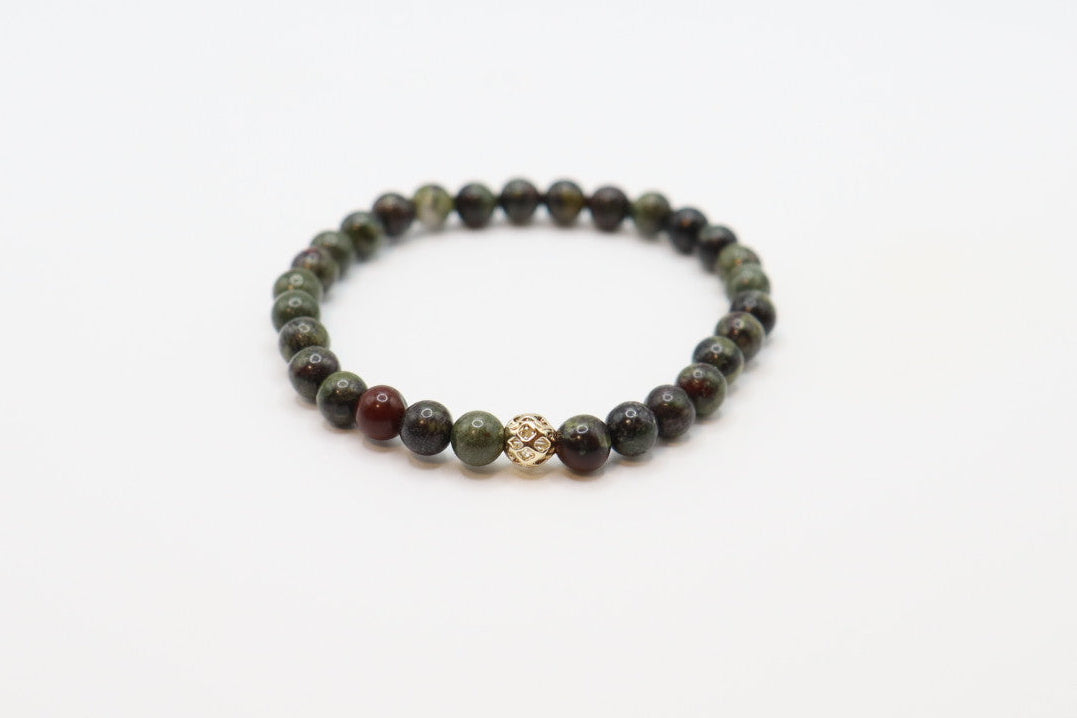 Crafted with striking Dragon Blood Jasper, this bracelet is made for strength, courage, and bold energy. 

Known for its grounding and revitalizing properties, this stone is believed to inspire resilience, confidence, and a fierce sense of purpose. Its rich green and red tones make it a standout piece that adds intention and power to any look. 

Wear it as a reminder of your inner fire and unstoppable spirit.
