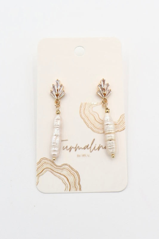 A pair of gold and white dangle earrings displayed on a cream-colored branded card. The earrings feature a gold-toned top setting with clear zirconia crystals, a small gold bead, and a white textured bead drop.
Perfect for brides, bridal 