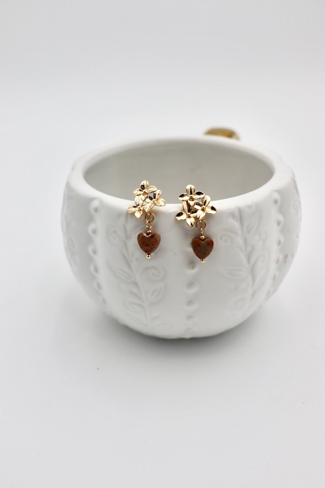 A celebration of strength and passion. Deep red jasper hearts — known for grounding and vitality — are paired with a delicate gold-plated flower, symbolizing growth, love, and beauty. A piece to wear your heart boldly.